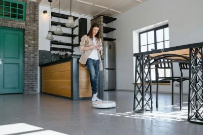 Kobieta korzystająca z inteligentnych urządzeń w nowoczesnej, energooszczędnej kuchni.