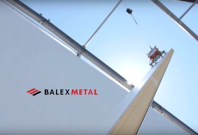 Montaż długiej płyty warstwowej PIR za pomocą przyssawek próżniowych na budowie mroźni.