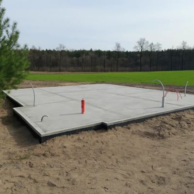 Gotowa płyta fundamentowa z wyprowadzonymi instalacjami, często z wbudowaną izolacją
