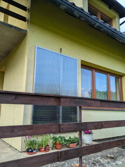 Wielkopowierzchniowy kolektor słoneczny z poliwęglanu komorowego zamontowany na ścianie domu.