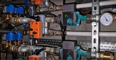 Widok na rozbudowaną kotłownię z rozdzielaczami i pompami