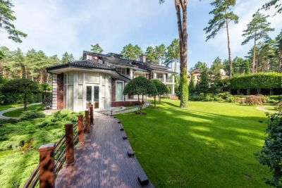 Nowoczesny dom pasywny otoczony zielenią, symbolizujący komfort i optymalny klimat wewnętrzny.