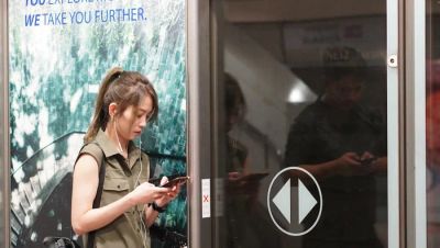 Kobieta sterująca inteligentnym urządzeniem AGD w domu za pomocą smartfona