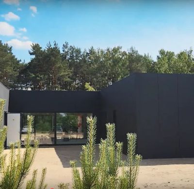 Nowoczesny dom jednorodzinny z elewacją z płyt warstwowych PIR montowanych pionowo.