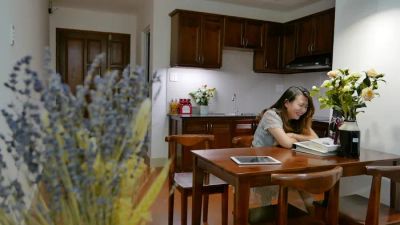 Kobieta zarządza systemem smart home na tablecie w nowoczesnej kuchni